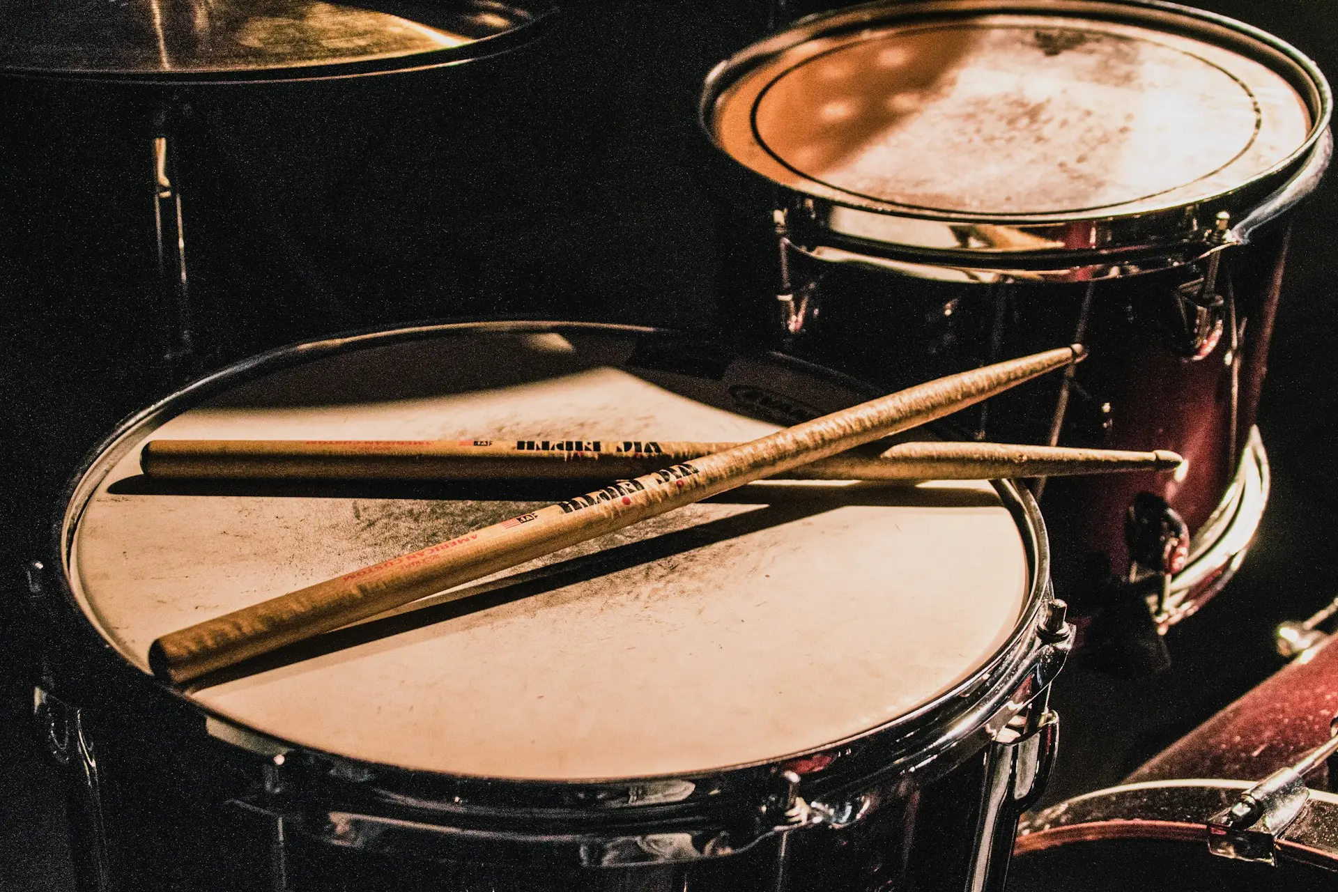 Worn drumsticks resting on a snare drum