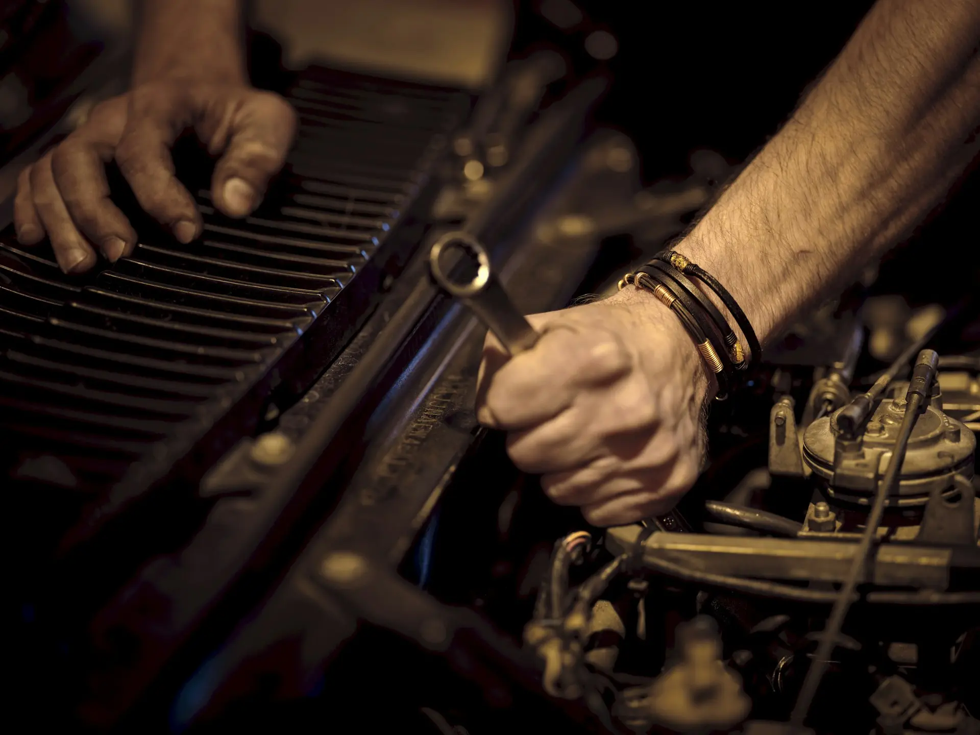 Mechanic's hands with Guard-Tex tape working on an engine