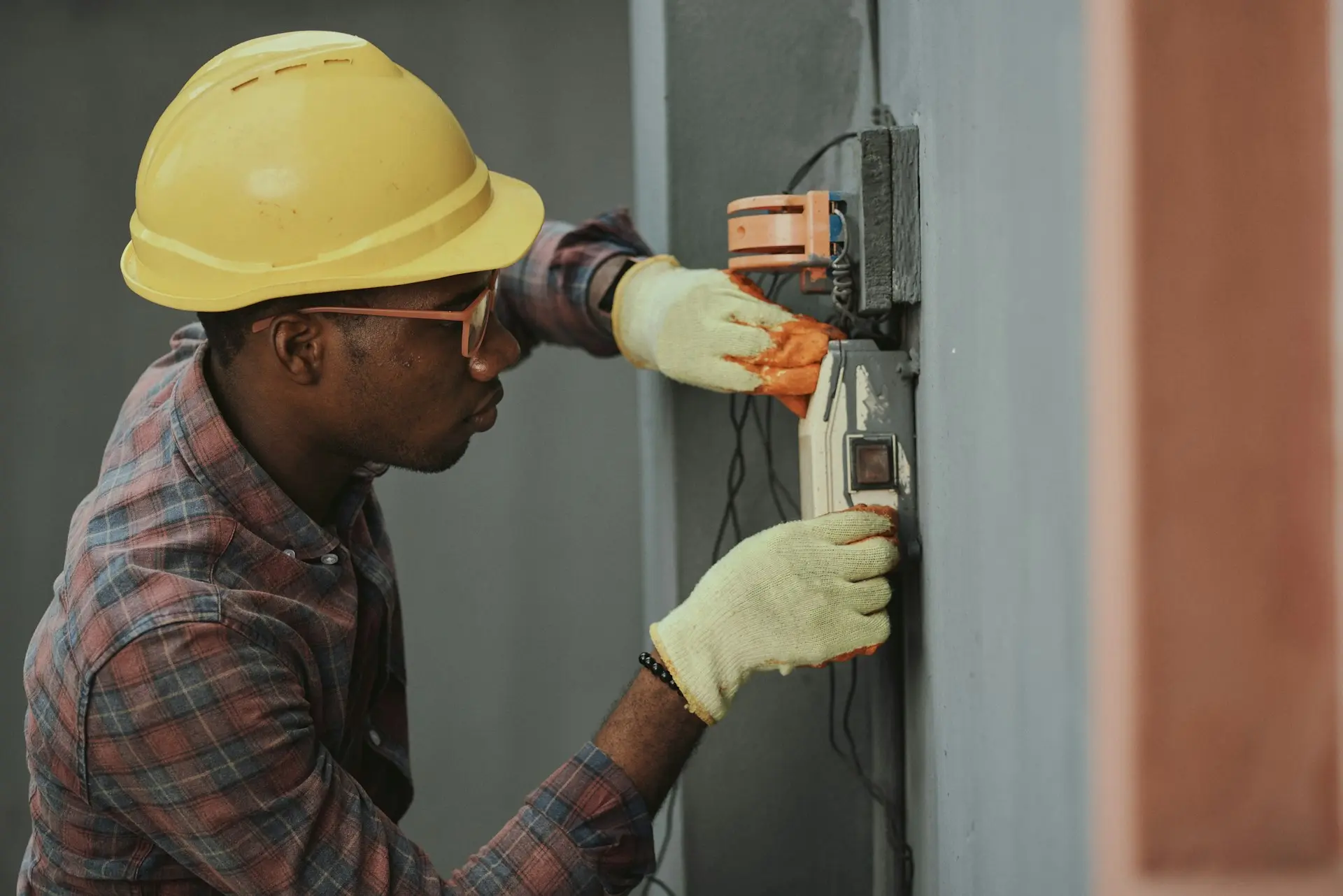 Electrician's taped fingers working inside a breaker panel